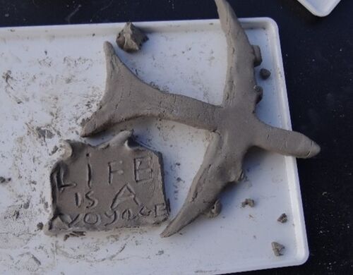 clay sculpture of aeroplane and plaque reading "life is a voyage"