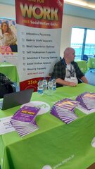 Gerry sitting at a table covered in copies of Working for Work